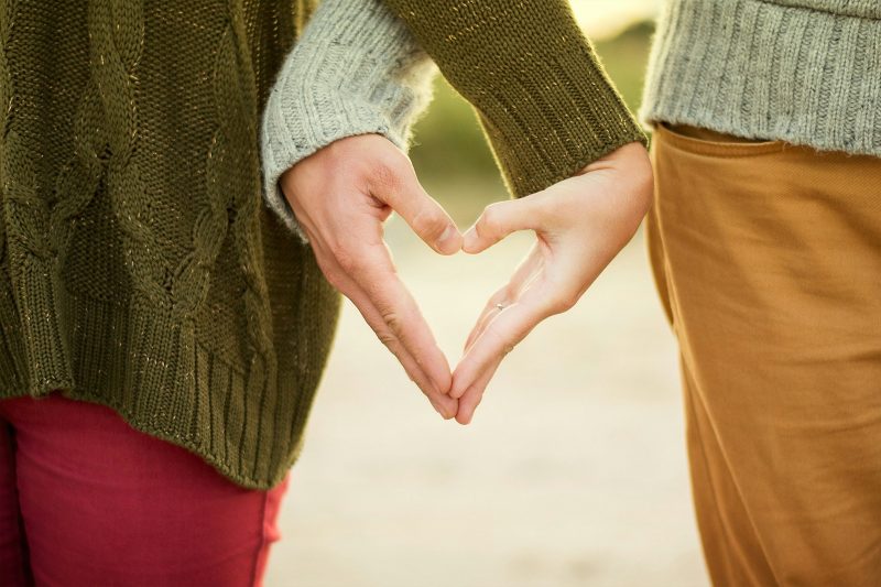 Couple holding hands in a heart shape symbolising intimacy, connection and low libido during menopause.
