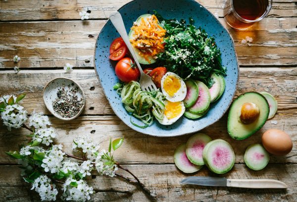 Healthy food bowl on wooden table with nutritious ingredients scattered, perfect for perimenopause nutrition.